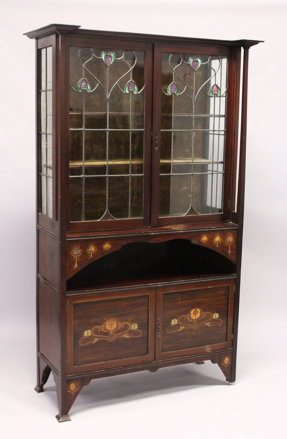 AN ART NOUVEAU MAHOGANY INLAID CHINA CABINET with a pair of leaded glass doors over an open space,