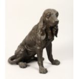 A NATURALISTICALLY MODELLED AND CAST BRONZE FIGURE OF A SEATED DOG. 1ft 2ins high.