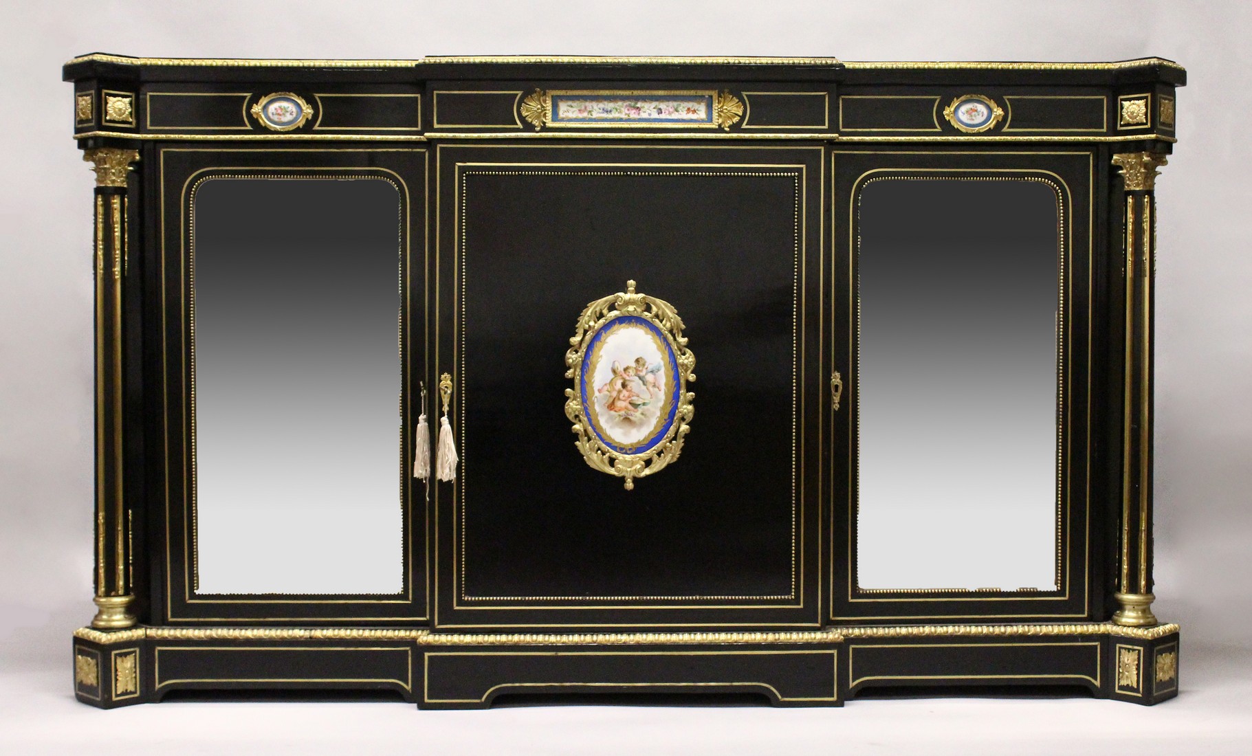 A VERY GOOD 19TH CENTURY FRENCH EBONY BREAK FRONT CREDENZA, with ornate mounts inset with Sevres