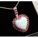 A SILVER RUBY AND OPAL HEART PENDANT on chain