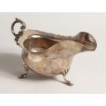A SILVER SAUCE BOAT, with scroll handle on shell and hoof feet. Sheffield 1903 7ozs