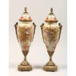 A PAIR OF PORCELAIN AND ORMOLU MOUNTED VASES AND COVERS, in the Sevres style. 15ins high.