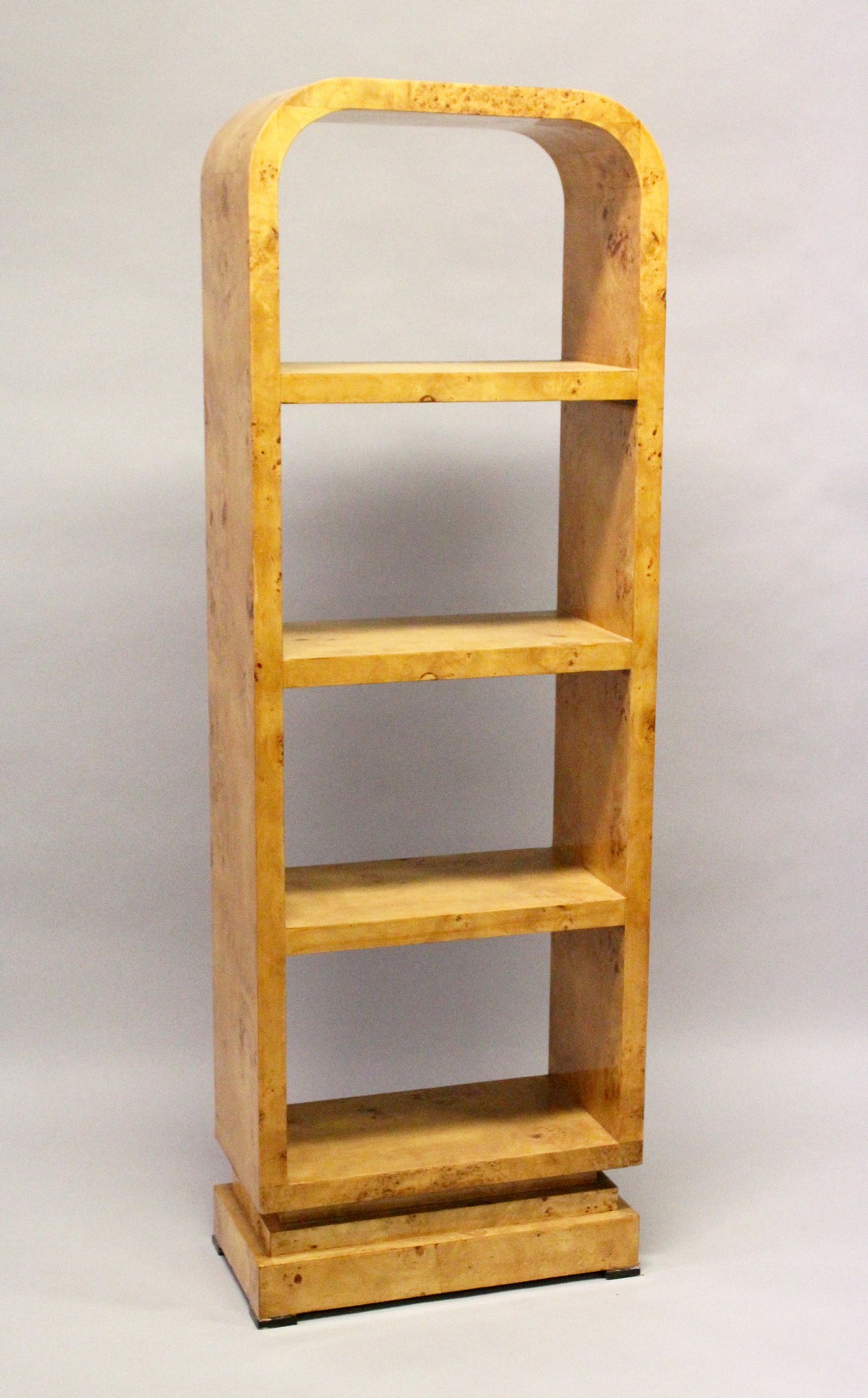 AN ART DECO STYLE BURR WOOD FREE STANDING OPEN BOOKSHELF, with four shelves on a platform base.