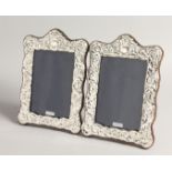 A PAIR OF SILVER REPOUSSE UPRIGHT PHOTOGRAPH FRAMES 8ins x 5.5ins
