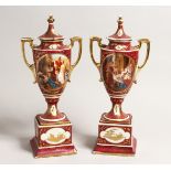A PAIR OF 19TH CENTURY VIENNA TWO HANDLED URN SHAPE VASES AND COVERS, painted with classical scenes.