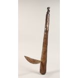 A TRIBAL WOODEN AXE carved with a figure. 23.5ins long
