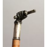 A 19TH CENTURY CANE with plated handles as a clenched fist holding a gun. Inscribed `RAYNER' 35ins