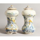 A PAIR OF ITALIAN MAJOLICA SPICE JARS AND COVERS painted with figures in blue and yellow. `TO