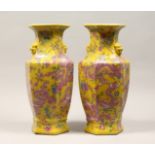 A PAIR OF CHINESE PORCELAIN HEXAGONAL SHAPE VASES, yellow ground, painted with dragons 17ins high