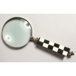 A MAGNIFYING GLASS with chequered handle