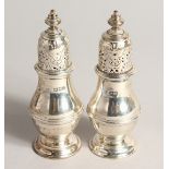 A PAIR OF PLAIN SILVER BALLISTER SHAPED PEPPERETTES. London, 1913 4.25ins high.