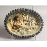 A 17TH - 18TH CENTURY MAJOLICA OVAL DISH with blue border, the centre with cupids and dolphins.