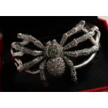 A SILVER EMERALD AND MARCASITE SPIDER BANGLE