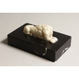 A CARVED WHITE MARBLE LION on a black base 6ins long