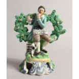 A PRATT WARE BOCAGE GROUP OF A SEATED MAN dog at his side playing a flute. 6ins high.