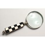 A MAGNIFYING GLASS with chequered handle