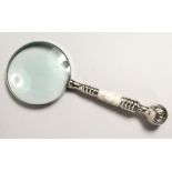 A MAGNIFYING GLASS with mother of pearl and chrome handle.