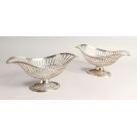 A PAIR OF SILVER OVAL PEDESTAL BASKETS, of openwork design, with reeded borders and foot rim.