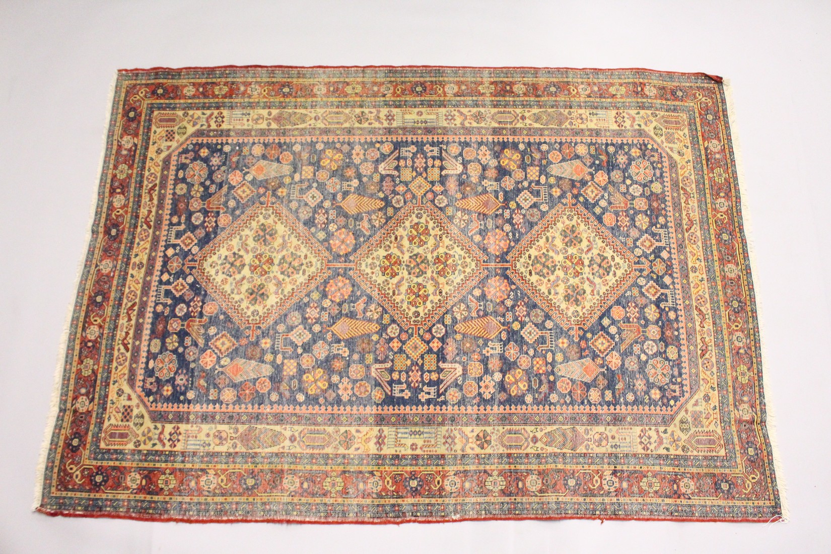 A PERSIAN QUASHQI CARPET, dark blue ground with three central diamond shaped medallions stylised - Image 2 of 2