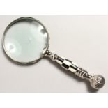 A MAGNIFYING GLASS with chequered handle.