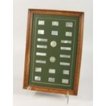 TWENTY TWO ENGRAVED MOTHER OF PEARL COUNTERS in a frame. 12ins x 17ins.