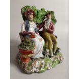 A GOOD PRATTWARE GROUP, A MAN AND WOMAN ON A BENCH a dog by their side 8ins high.