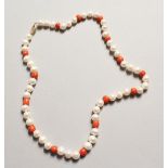 A STRING OF PEARL AND CORAL BEADS with 14ct gold clasp.