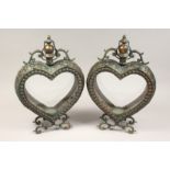 A PAIR OF HEART SHAPED GREEN PATENATED AND COPPER COLOURED HANGING LANTERNS. 21in high.