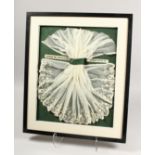A SUPERB NAPOLEON III WHITE LACE FOR A COT, framed and glazed. 19in x 15ins.