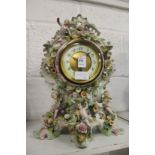 A continental mantle clock, the porcelain body with floral encrusted and cherub decoration.