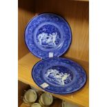 A pair of blue and white plates decorated with cherubs.