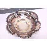 A silver pedestal bowl with pierced decoration, engraved with various signatures.