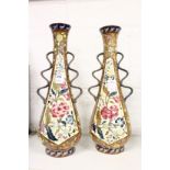 A pair of Austrian twin handled pottery vases painted with flowers.