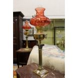 A good pair of Corinthian column brass oil lamps with ruby coloured shades.