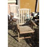 A pair of folding hardwood garden armchairs.