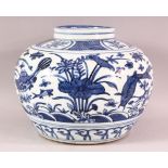 A CHINESE BLUE & WHITE PORCELAIN FISH POT - decorated with fish and lotus, 20.5cm high.