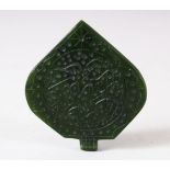 AN ISLAMIC CARVED JADE PENDANT, the pendant with engraved calligraphy, 6.5cm x 6cm.