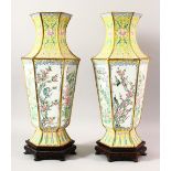 A LARGE PAIR OF CHINESE ENAMEL VASES & STANDS, the vases decorated upon a yellow ground with