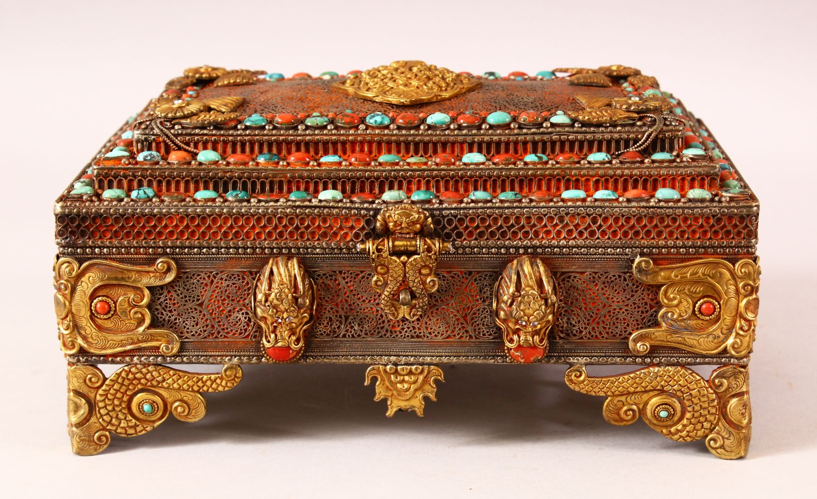 A TIBETAN MOUNTED AND INLAID METAL CASKET, the body with openwork style inlay, with gilt raised