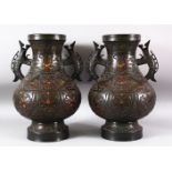 A PAIR OF JAPANESE CHAMPLEVE BRONZE CLOISONNE TWIN HANDLE VASES, the body decorated with enamelled