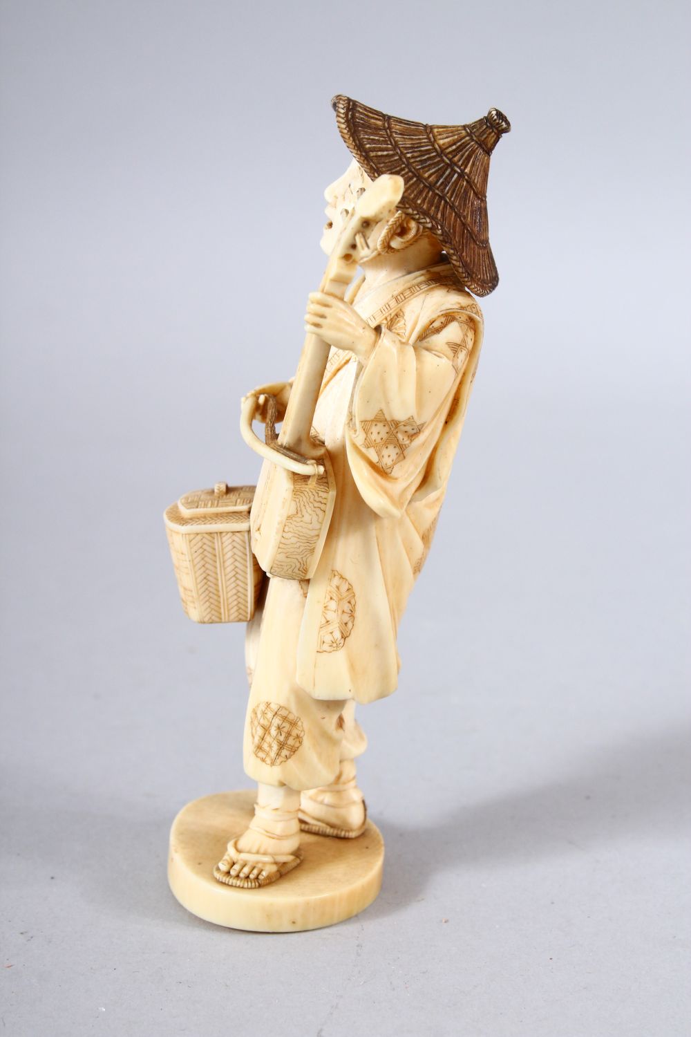 A JAPANESE MEIJI PEPRIOD CARVED IVORY OKIMONO - MUSICIAN - the figure stood holding his basket and - Image 4 of 8