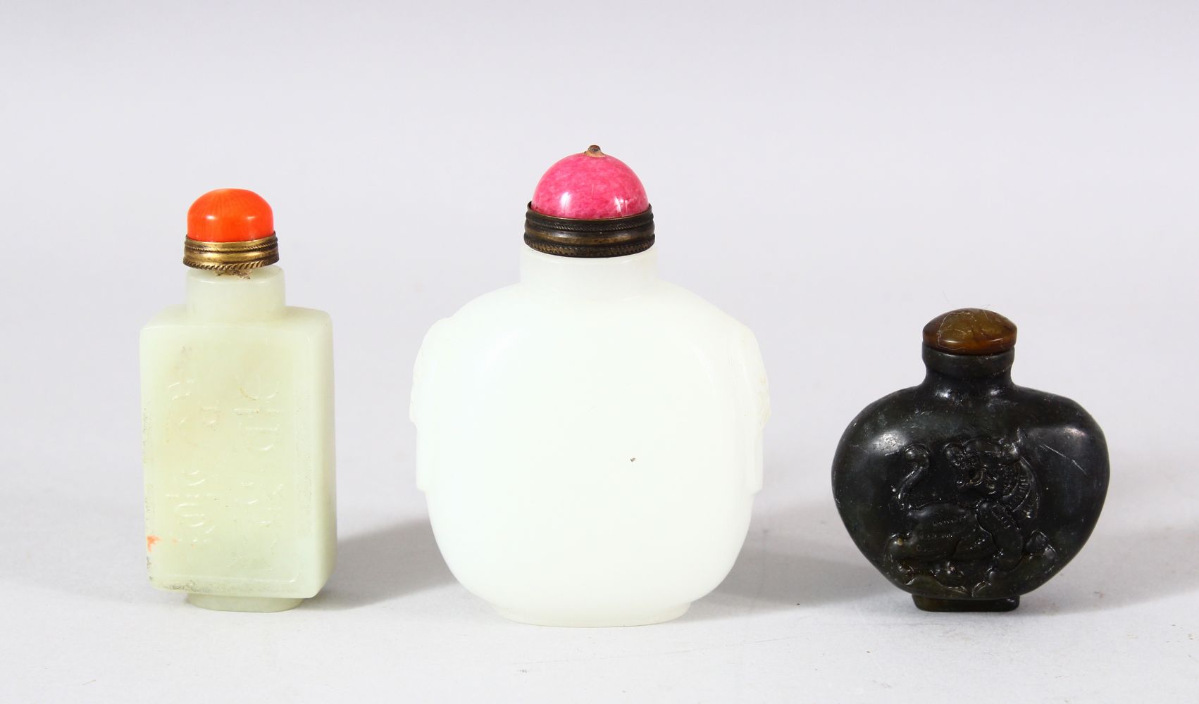 A MIXED LOT OF 3 CHINESE CARVED JADE SNUFF BOTTLES - each of varying medium and style - one carved