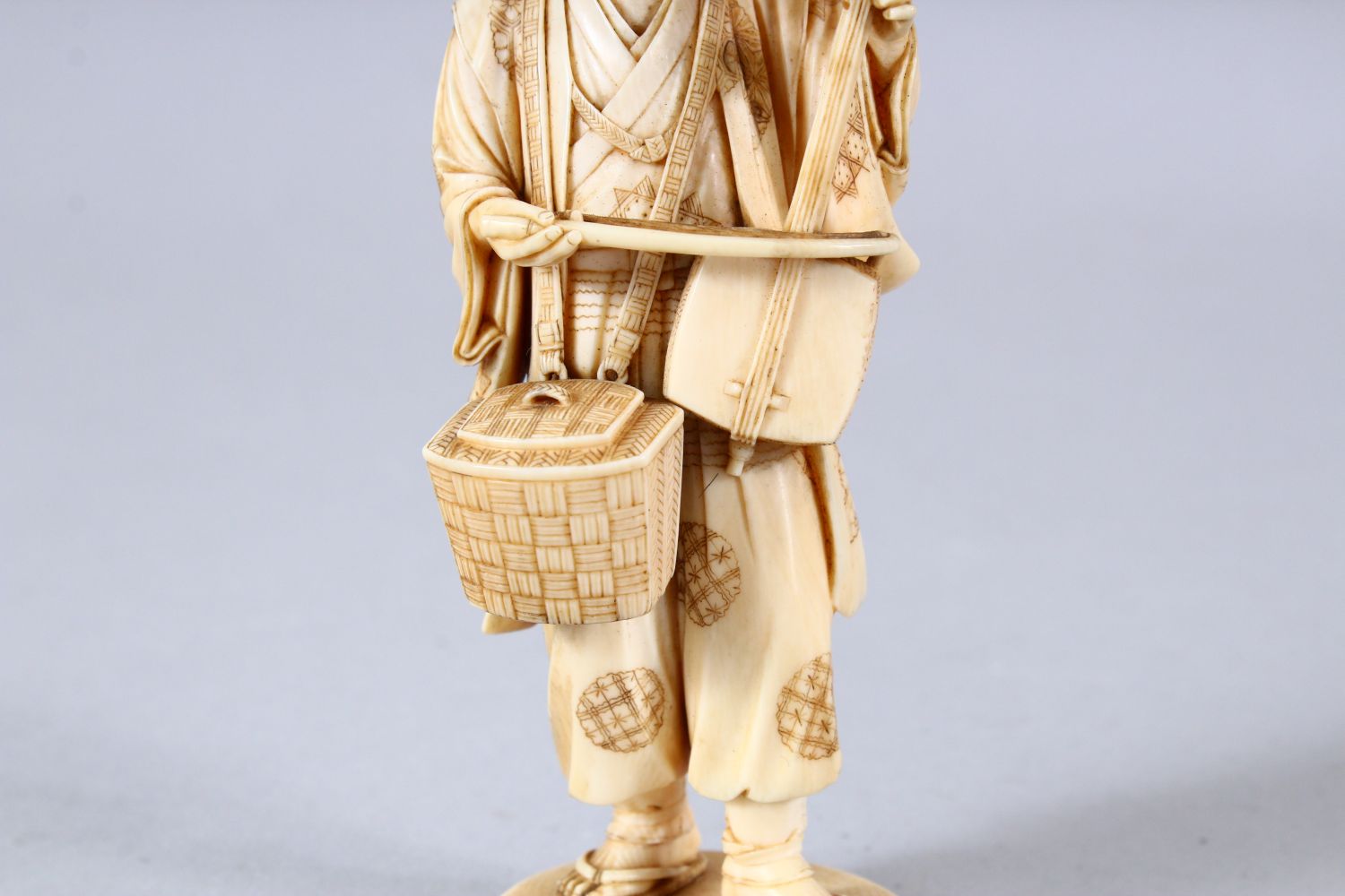 A JAPANESE MEIJI PEPRIOD CARVED IVORY OKIMONO - MUSICIAN - the figure stood holding his basket and - Image 6 of 8