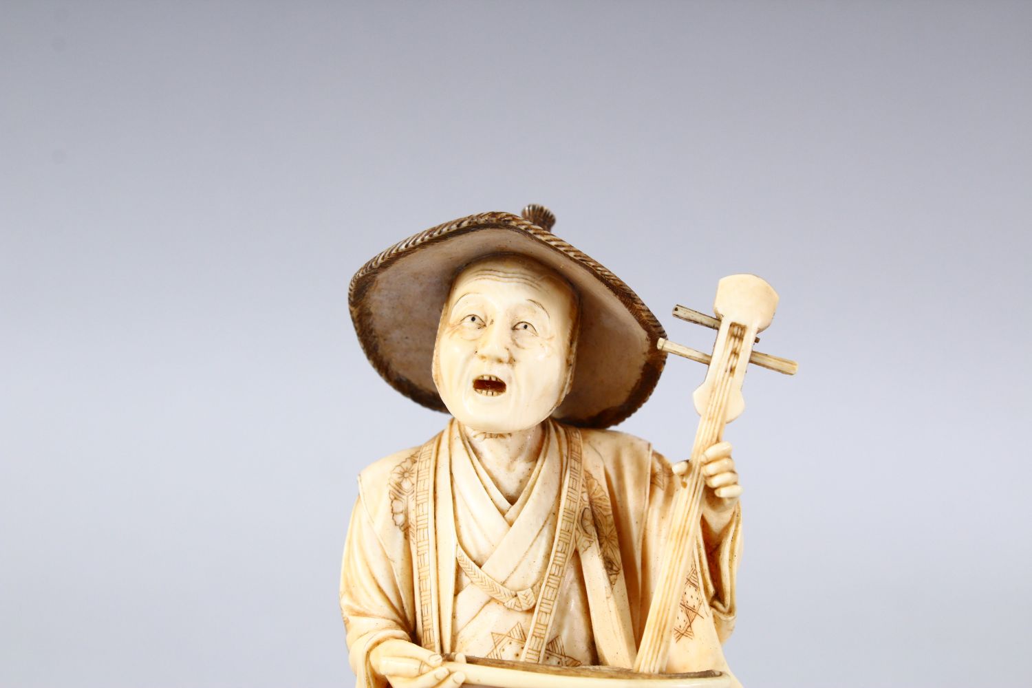 A JAPANESE MEIJI PEPRIOD CARVED IVORY OKIMONO - MUSICIAN - the figure stood holding his basket and - Image 5 of 8