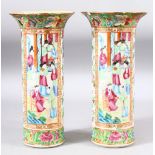 A PAIR OF CHINESE CANTON SLEEVE VASES, painted with panels of figures and bands of flora and