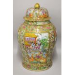 A LARGE CHINESE CANTON URN AND COVER, painted with panels of figures, profusely decorated with