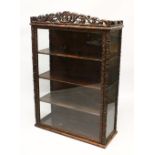 A 19TH CENTURY CHINESE CARVED HARDWOOD AND GLASS DISPLAY CABINET, profusely carved with fruit and