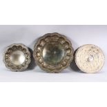 THREE INDIAN WHITE METAL EMBOSSED DISHES - each of varied design and size - 24cm - 34cm