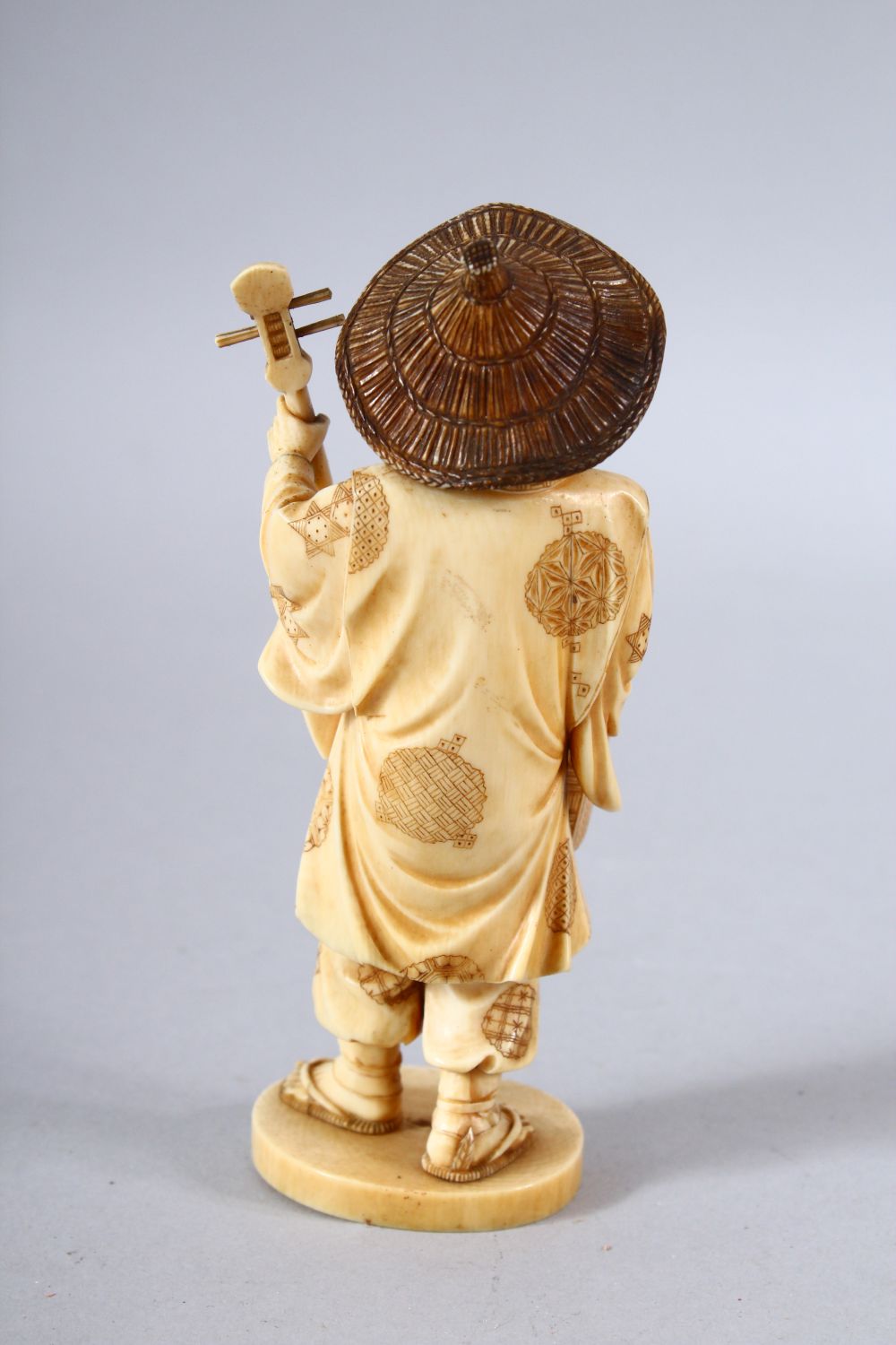 A JAPANESE MEIJI PEPRIOD CARVED IVORY OKIMONO - MUSICIAN - the figure stood holding his basket and - Image 3 of 8