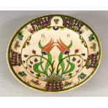 AN IZNIK STYLE POTTERY DISH, possibly European, decorated with stylised flowers, 25cm diameter.